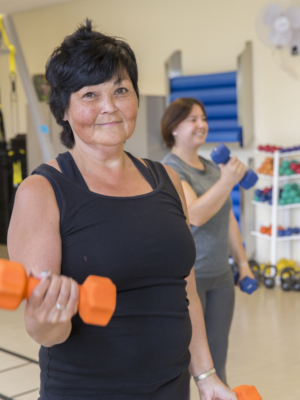 Woman lifting orange dumb bell weights