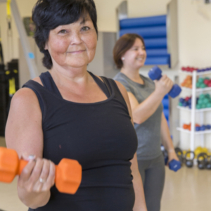Woman lifting orange dumb bell weights