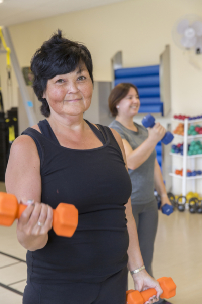 Woman lifting orange dumb bell weights