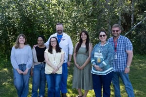 Team of health care professionals in a forested setting. 